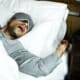 a man with sleep apnea sleeping on a bed